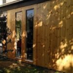 Neue Holzfassade aus Nut-und-Feder-Profilbrettern mit zwei schmalen Fenstern
