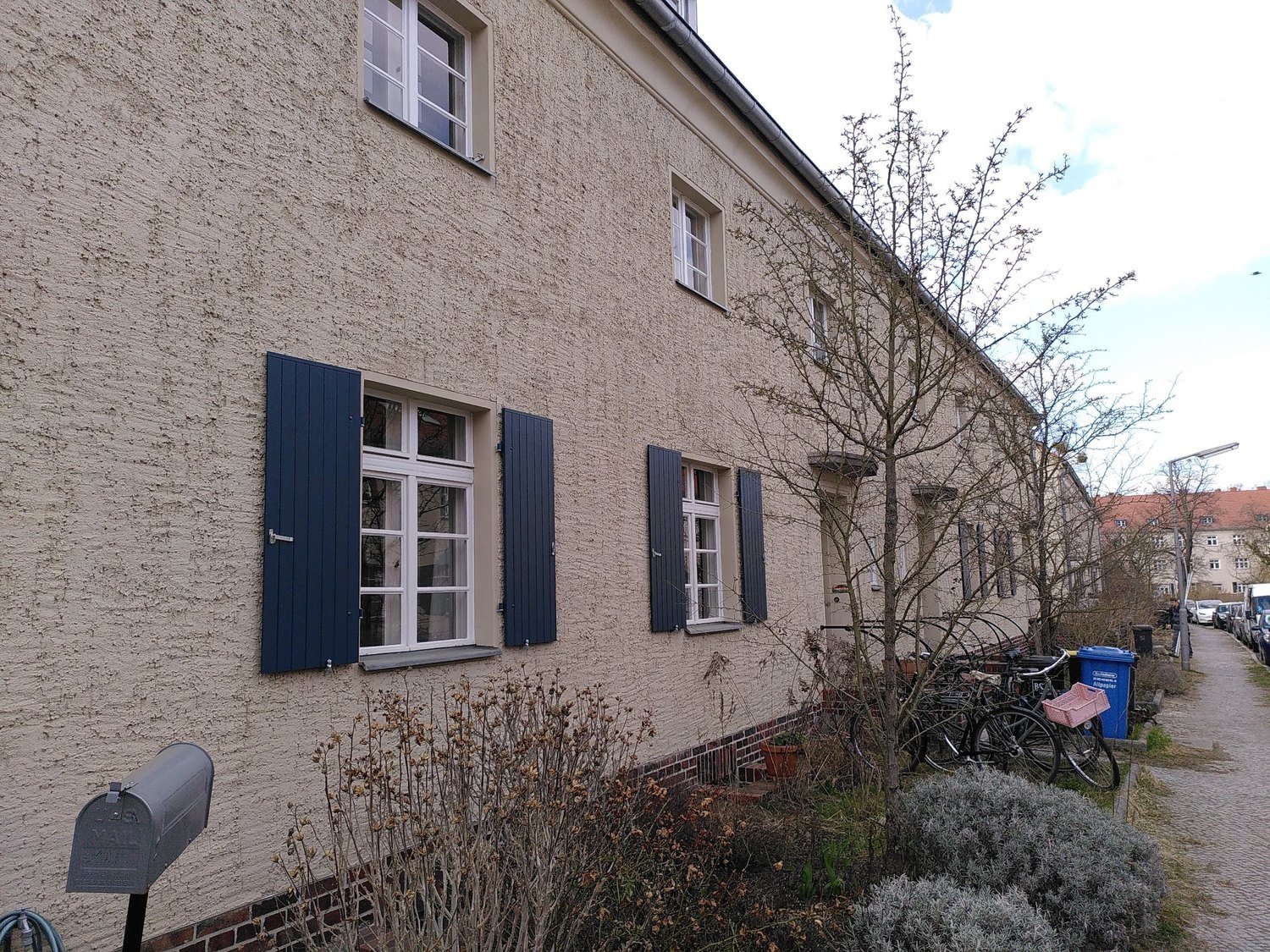 Restaurierte, dunkelblau gestrichene Fensterläden an einem Reihenhaus