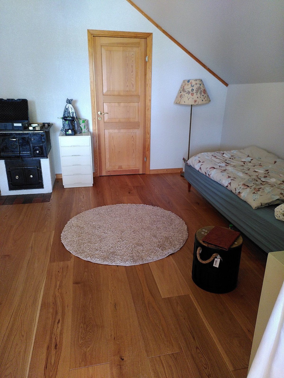 Newly laid oak parquet in a bedroom with tiled stove, holiday home in northern Sweden