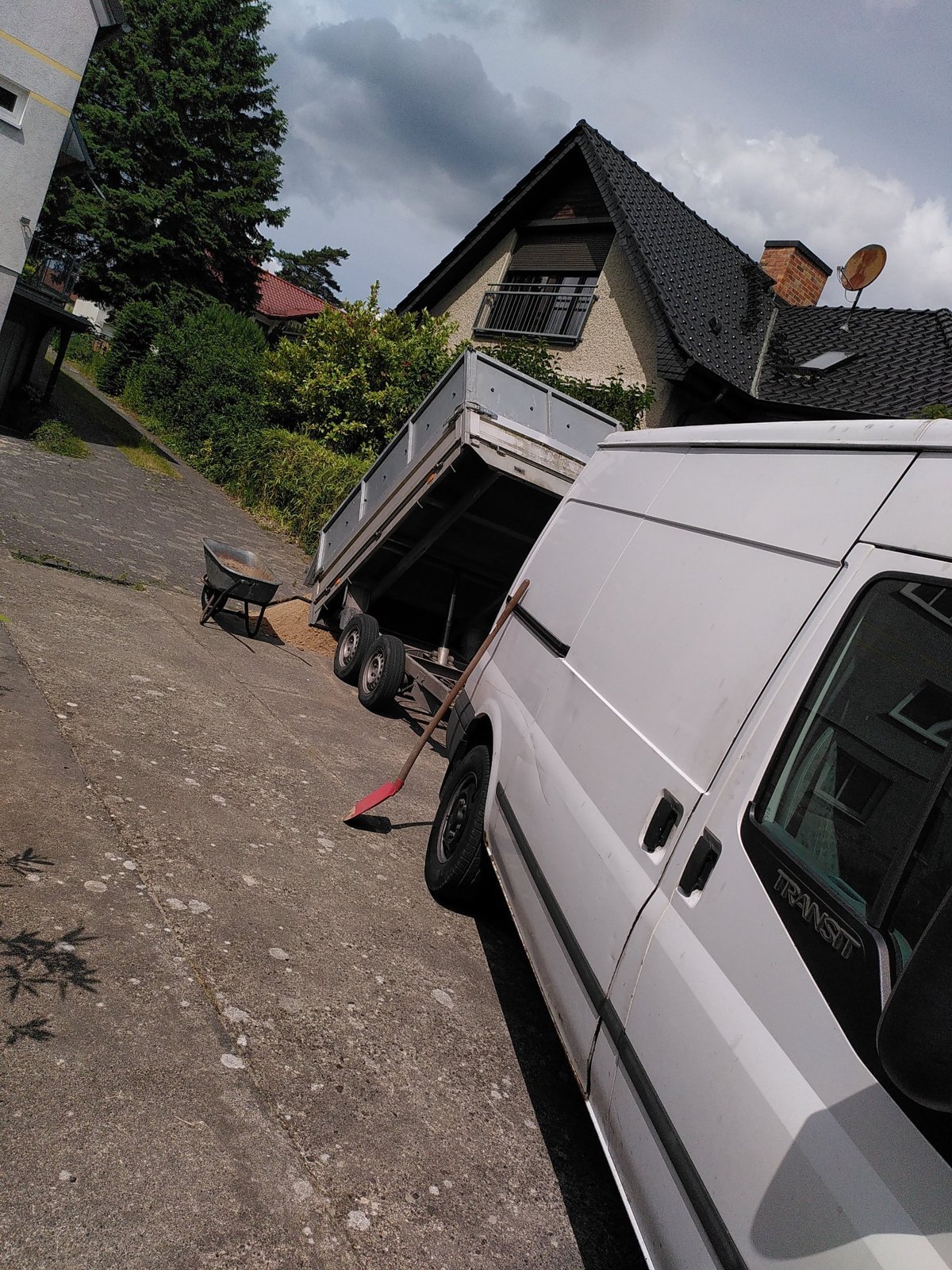 Skåpbil med släp framför tomten vid borttransport av poolen