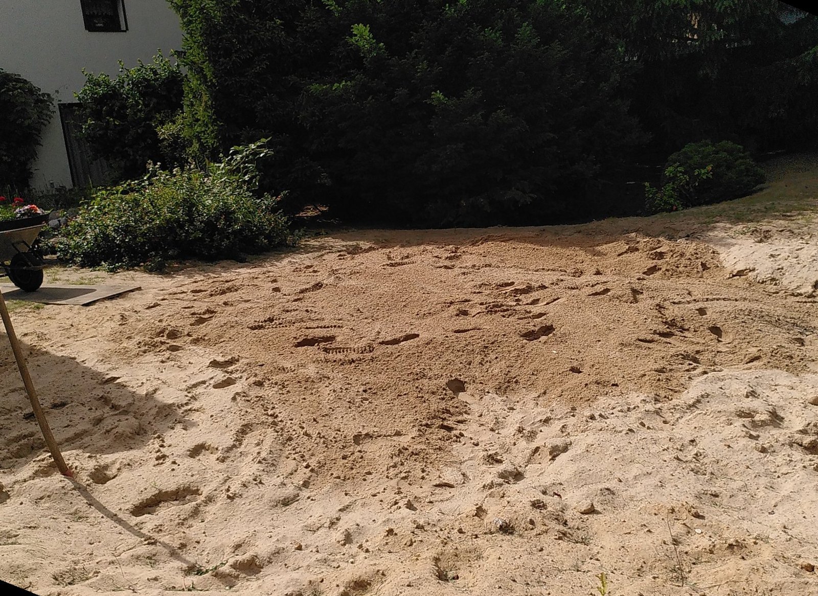 Sandfyllning i den gamla poolgropen i trädgården