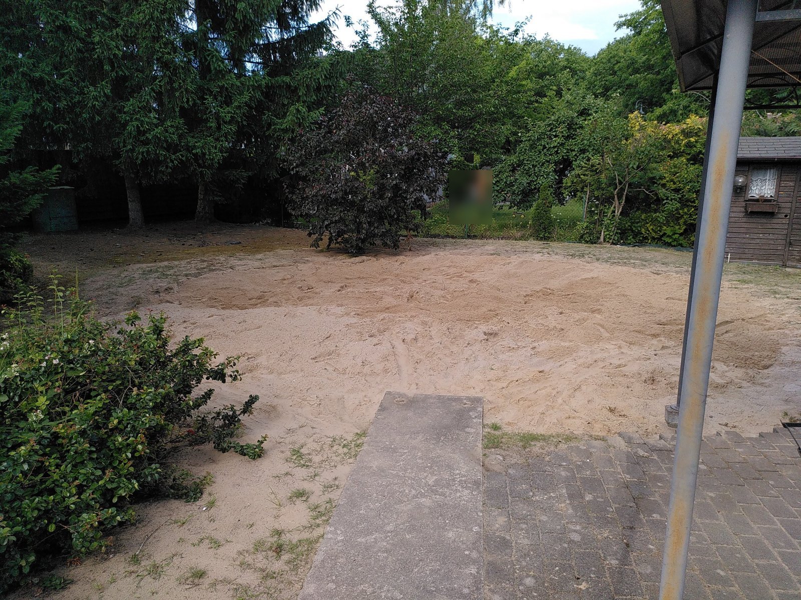 Återfylld yta med sand, vy in i trädgården